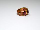 a gold ring with a red stone in it