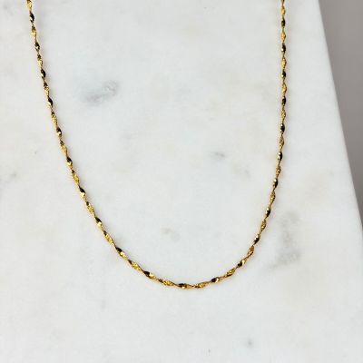 une photo d'un collier à chaîne en or posé sur une surface en marbre