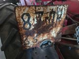 a rusted sign on the front of a tractor