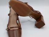 the woman ' s shoes are brown and brown on a white surface