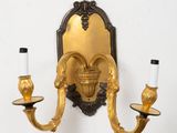 a gold wall sconce with two candles on it