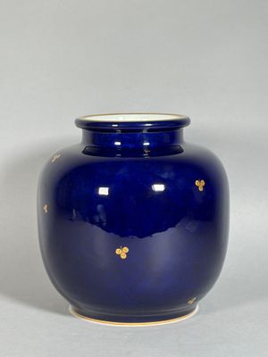 un vase bleu orné d'une décoration dorée
