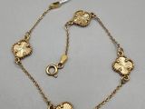 an image of a gold bracelet with flowers on it
