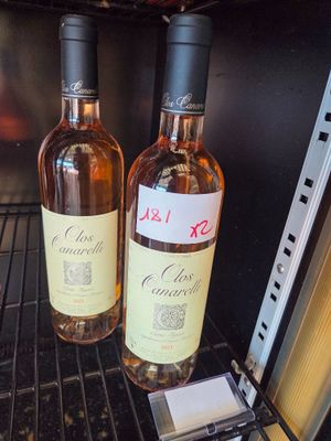 two bottles of wine sitting on a shelf in a wine cooler