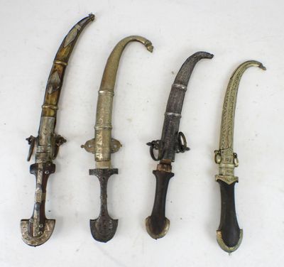 four different types of knives are lined up on a white surface