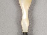 a close up of a spoon on a white surface with a black handle