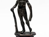 statue en bronze représentant un homme tenant un bâton, posée sur un socle