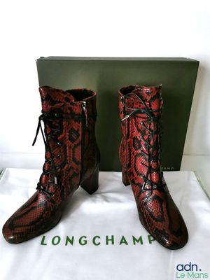 des bottes en peau de serpent rouges et noires, ornées de lacets noirs