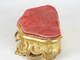 an image of a small gold and red box on a white surface