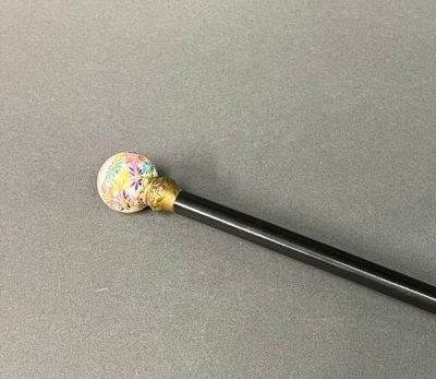 un bâton noir surmonté d'une balle colorée