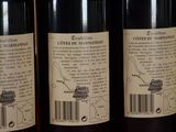 three bottles of wine are lined up on a shelf