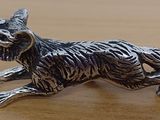 figurine de chat plaquée argent posée sur une table en bois