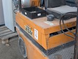 a forklift with a seat on it in front of a building