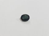 a green sapphire stone on a white surface