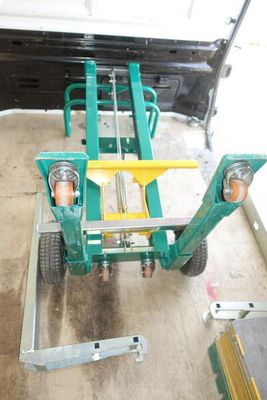 un chariot vert avec une poignée jaune dans un garage