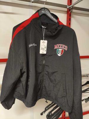 une veste noire et rouge suspendue à un portant dans un magasin