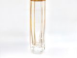 a clear glass vase with a gold rim sitting on a white surface