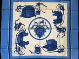 a blue and white square scarf with a picture of a horse drawn carriage