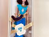 barbie doll in a box with a blue dress and gold accessories