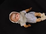 a small doll that is laying down on a black surface