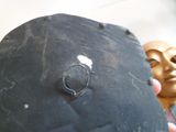 une main tenant un objet noir avec un anneau dessus