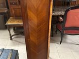 a tall wooden cabinet in the middle of a room