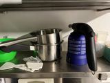 stainless steel counter top with pots and pans on top of it