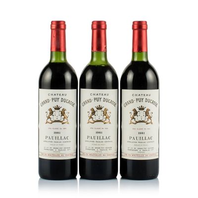 three bottles of red wine sitting next to each other on a white surface