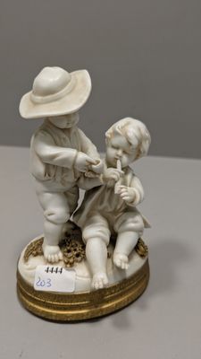 a figurine of a boy and a girl playing with a dog