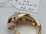an image of a gold ring with diamonds and a green stone