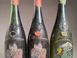 trois bouteilles de vin posées sur une table l'une à côté de l'autre