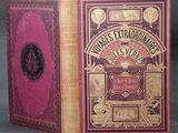 a close up of a book with a pink cover on a table
