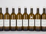 six bouteilles de vin sont alignées sur une surface blanche