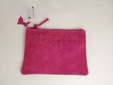 une pochette rose ornée de clous et de pompons