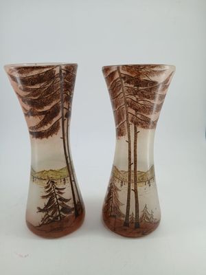 two vases that have been painted with trees on them