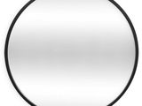 un miroir rond avec un cadre noir accroché à un mur blanc