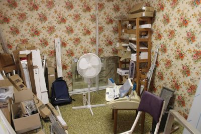 une pièce équipée d'un ventilateur, d'une chaise, d'une table et d'autres objets