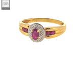 a gold ring with a ruby and diamond center