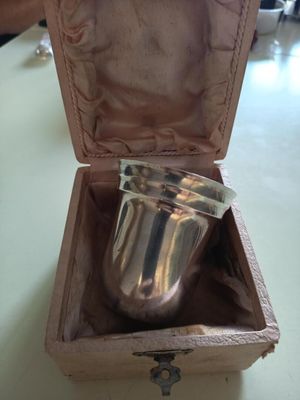 une coupe en argent dans un coffret en bois posé sur une table