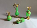 three green vases and two gold vases on a table
