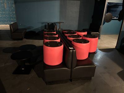 quatre tabourets rouges avec des assises noires dans une pièce