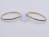 a close up of a pair of gold bracelets on a white background