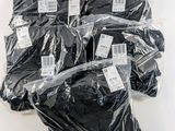 six bags of black underwear are wrapped in plastic on a white surface