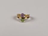 un gros plan d'une bague sertie d'une pierre verte et violette