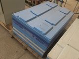 une pile de cartons bleus posée sur une palette dans un entrepôt
