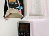 un petit appareil électronique posé sur une table à côté d'une boîte