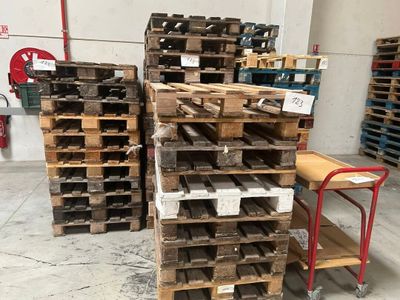 de nombreuses palettes en bois empilées les unes sur les autres dans un entrepôt