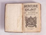 un livre ouvert sur lequel figure l'image d'un blason et un blason
