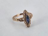 a close up of a gold ring with a blue stone