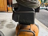 a small air compressor sitting on the side of the road